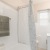 Large well lit bathroom with white cabinents